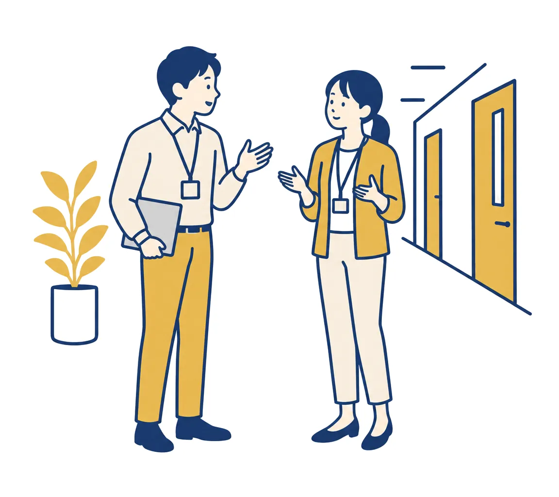 廊下で同僚に質問され、何もメモを取らずにその場で答えている担当者