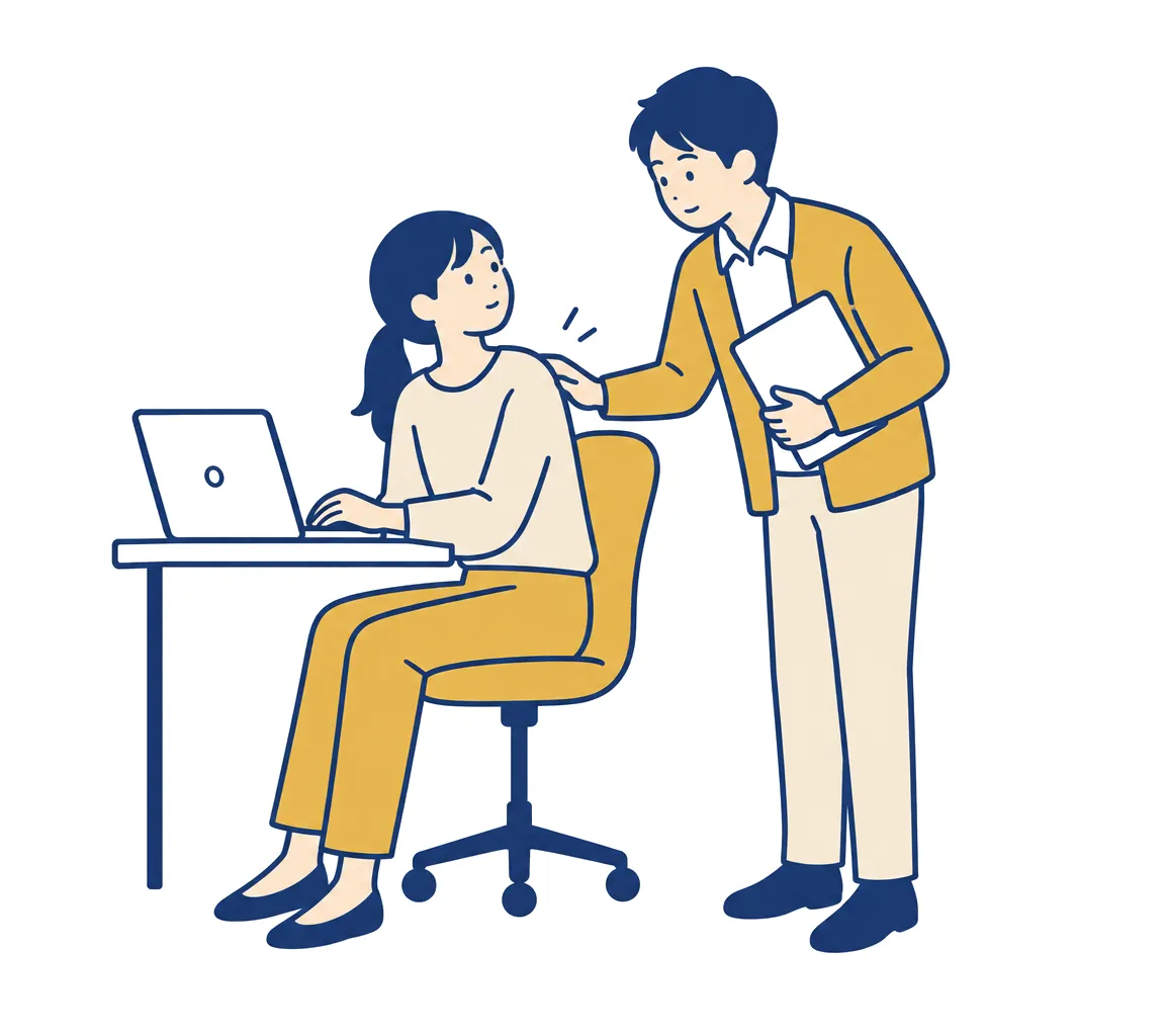 作業の途中で、書類を持った同僚に声をかけられる担当者